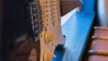 A guitar on a blue surface with a window in the background.