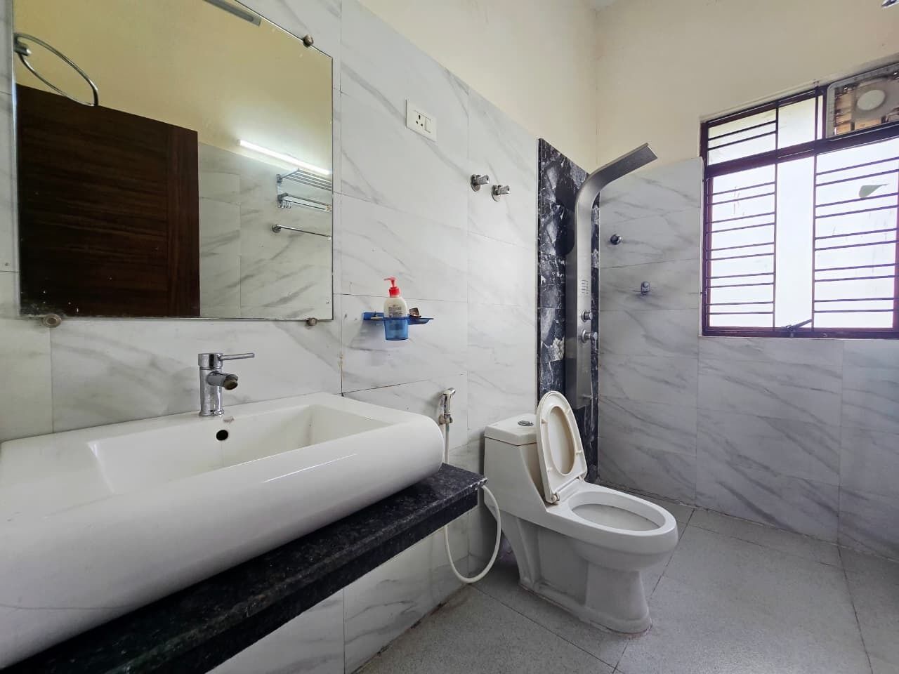 A bathroom with a white sink, a toilet, and a shower.