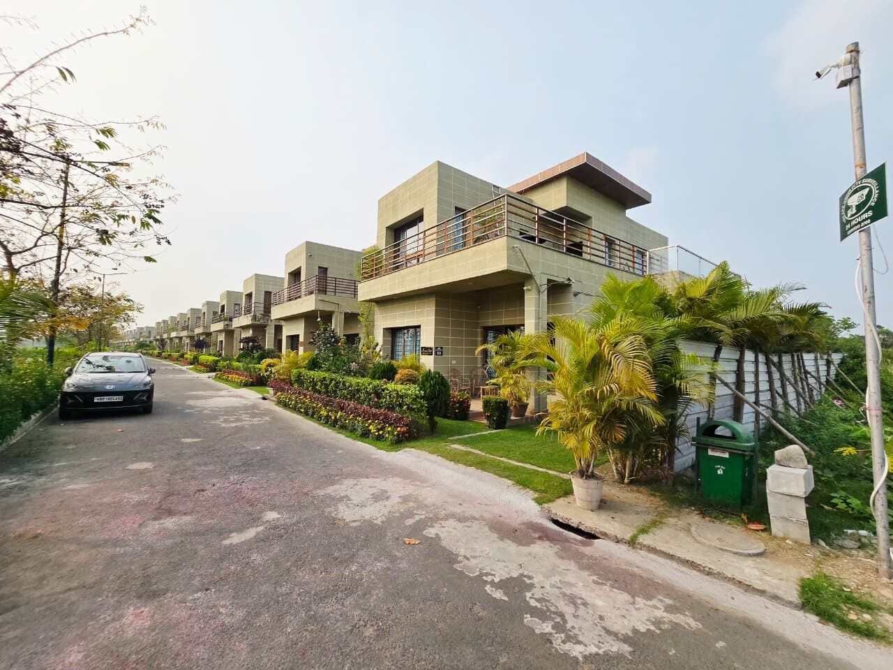 A residential building with multiple floors, balconies, and a well-maintained garden.