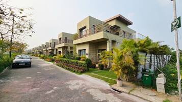 A residential building with multiple floors, balconies, and a well-maintained garden.