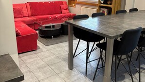 A modern kitchen with a dining table and chairs, a red sofa, and a window with a view. - Detached chalet 100m2 open view (Xonrupt-Longemer)