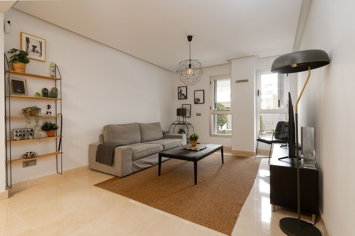 A modern living room with a sofa, coffee table, and a bookshelf.