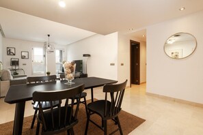 A modern dining area with a black table and chairs, a decorative vase, and a large mirror on the wall. - Acqua by Time & Home (San Pedro de Alcántara)