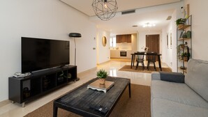 A modern living room with a flat-screen TV, a coffee table, and a sofa. - Acqua by Time & Home (San Pedro de Alcántara)