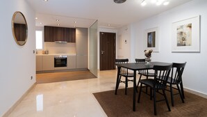 A modern kitchen with a dining area, featuring a large table and chairs, a wooden floor, and a large mirror on the wall. - Acqua by Time & Home (San Pedro de Alcántara)