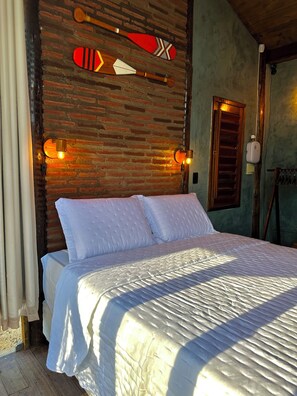 A bed with white bedding, a brick wall, and two wall-mounted lights. - Vila Calm bungalow - Ipu - Ceará - Serra da Ibiapaba (Várzea do Giló)