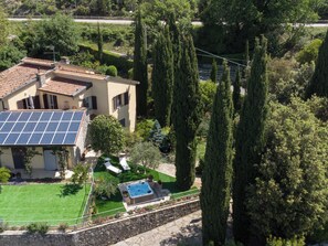 Ein Haus mit Solaranlage, Swimmingpool und einem gepflegten Garten.