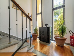 Eine Treppe mit schwarzen Balustraden, ein Kamin und Topfpflanzen.