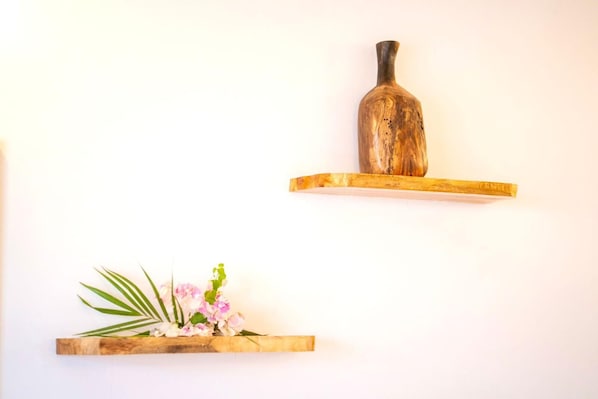 Zwei Holzregale, eines mit einer Vase und das andere mit einer Pflanze.