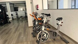 A gym with stationary bikes, weight machines, and a fire extinguisher on the wall. - Nairobi Accomodation (Nairobi)