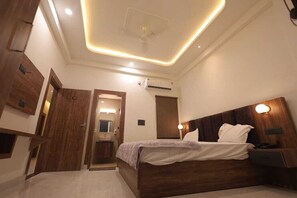 Un dormitorio moderno con cama de madera, lámparas de noche y una lámpara de techo.