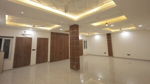 A spacious hotel room with a high ceiling, recessed lighting, and a polished floor. - Priya Kunj Dham (Mathura)