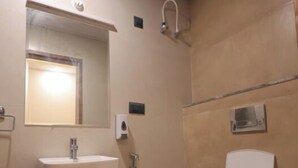 A bathroom with a sink, mirror, and toilet. - Priya Kunj Dham (Mathura)