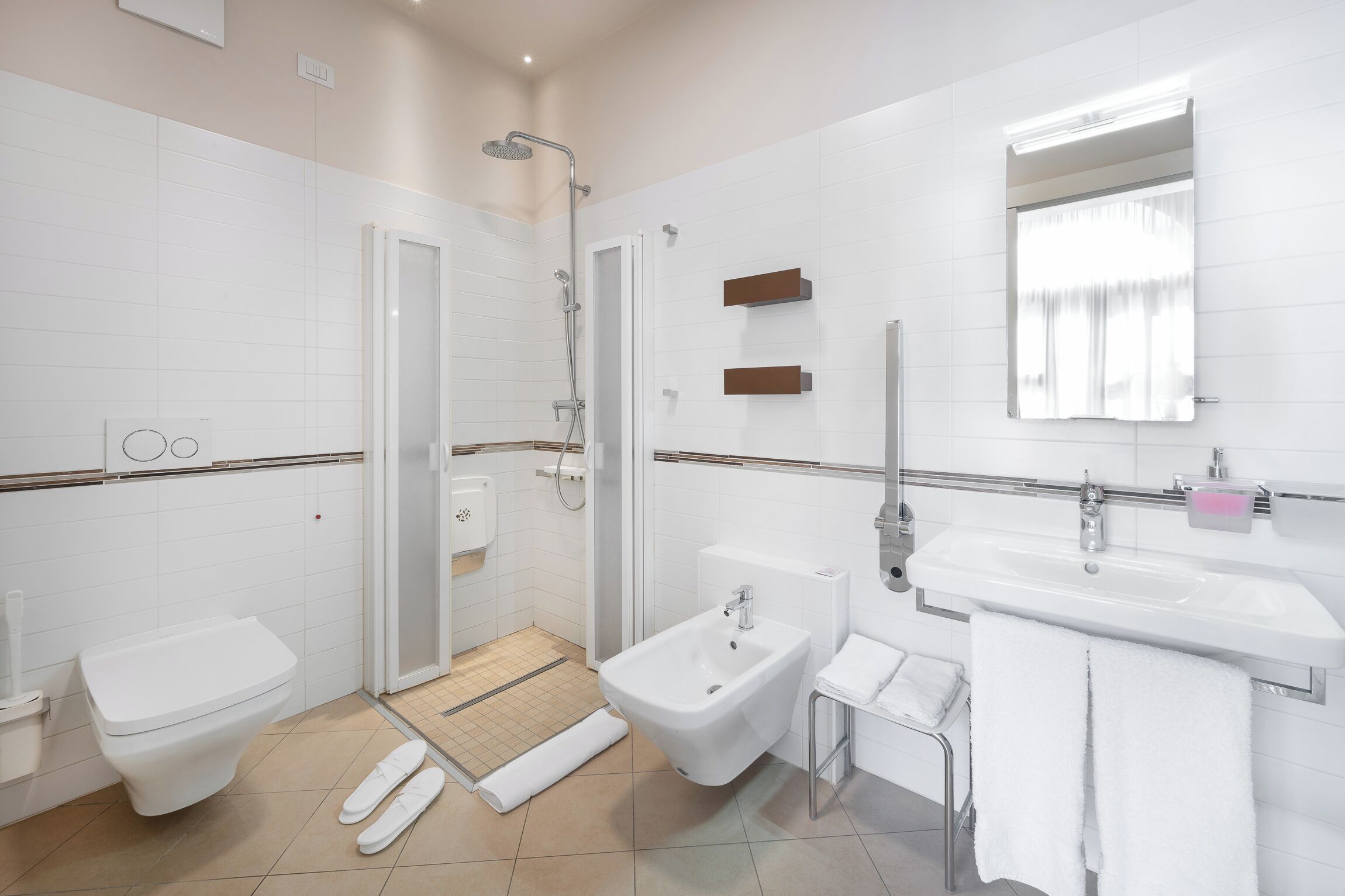 Un baño moderno con inodoro, bidé, ducha y lavamanos.