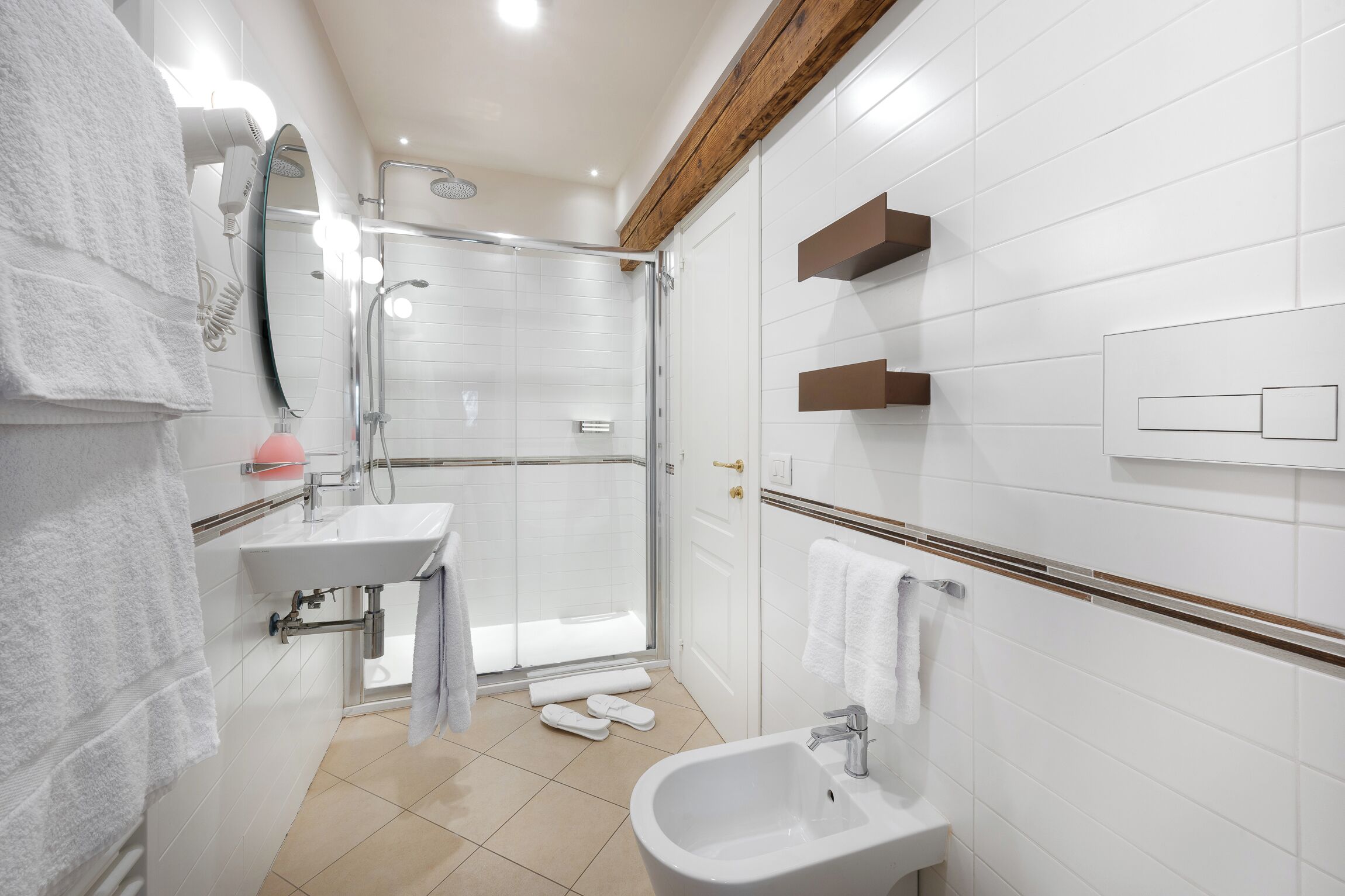 A modern bathroom with a shower, sink, and bidet.