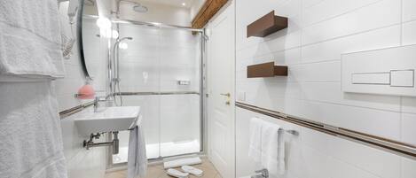 A modern bathroom with a shower, sink, and bidet.