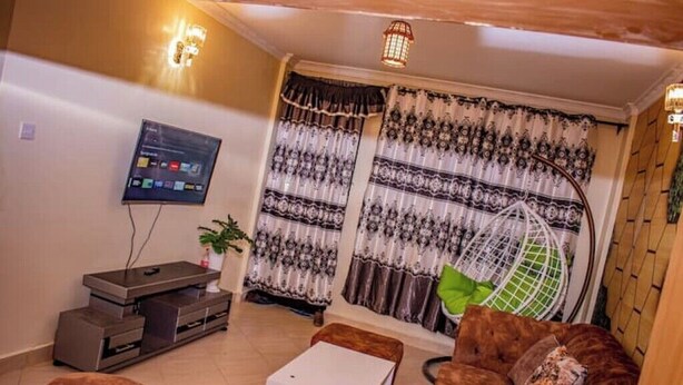 A living room with a TV, sofa, and a hanging chair. - Dandy Home, 2 BdRm, Estn Bypass Kamakis Greenspot (Ruiru)
