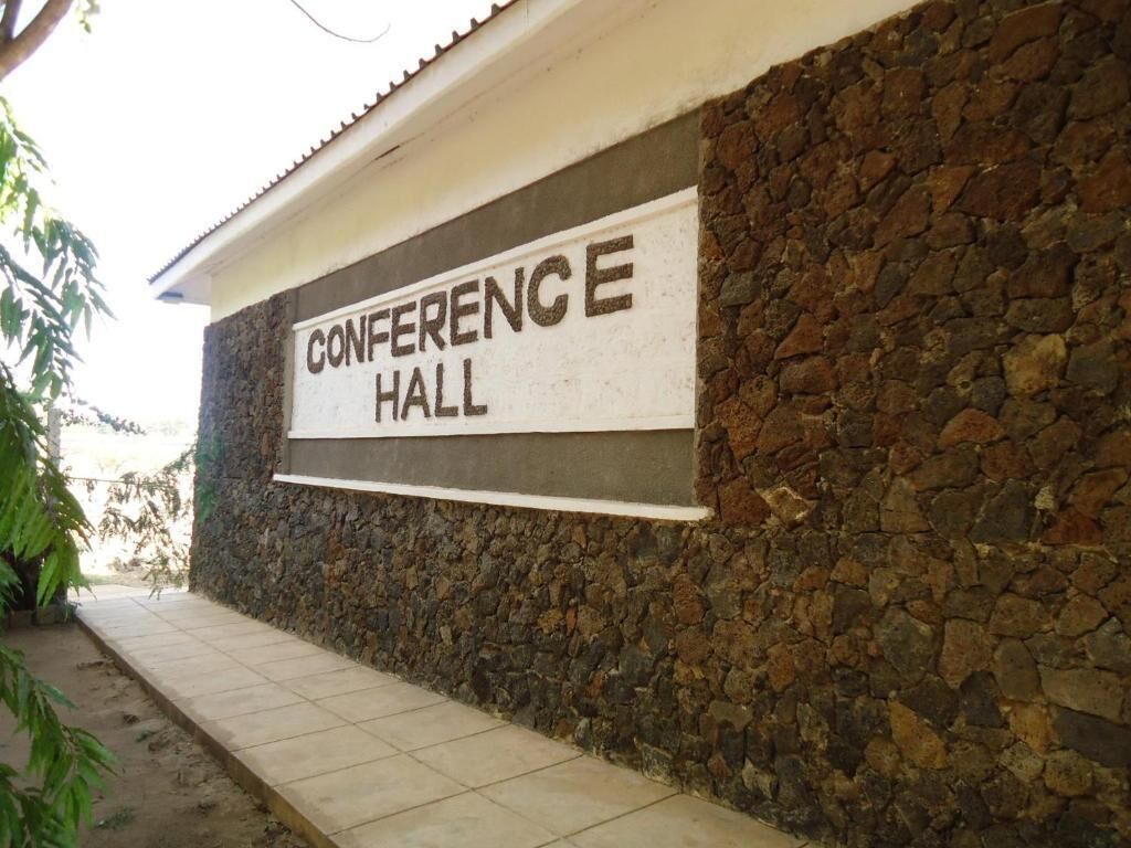 A stone wall with a sign that reads "CONFERENCE HALL".