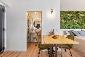 A modern kitchen with a wooden dining table, green chairs, and a breakfast setting. - Authentic Madeira stay • Ocean View Apartments (Caniço)