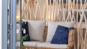 A modern interior with a sofa, wooden wall decor, and a hanging light fixture. - Authentic Madeira stay • Ocean View Apartments (Caniço)