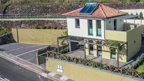 Ein modernes Gebäude mit Solaranlage, Balkon und Steinwand.