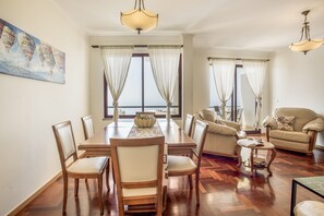 Un espacio comedor con una mesa y sillas de madera, un sofá y una pequeña mesa de centro.