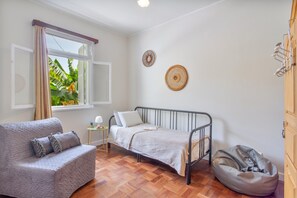 Una habitación con una cama, un sofá, una mesita y un sillón de saco.