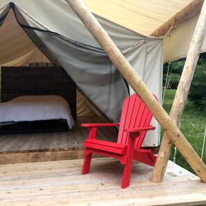 A tent with a bed and a red chair. - Homegrown Hideaway - The Lynn (Port Dover)
