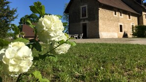 Un bâtiment en pierre avec un toit en pente, une fenêtre visible et une porte.