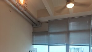 Een moderne woonkamer met een eethoek, grote ramen en uitzicht op de stad.