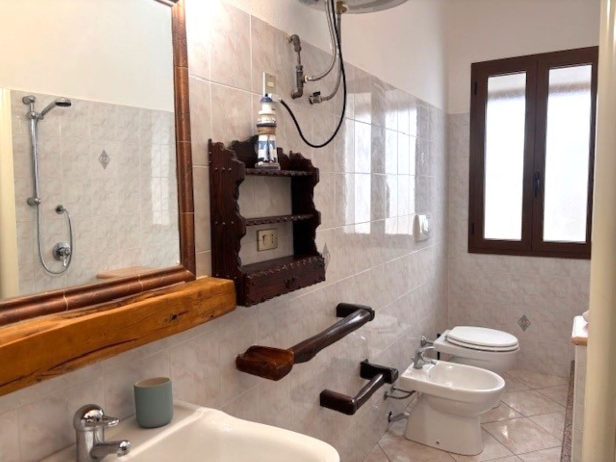 A bathroom with a shower, toilet, sink, and a mirror.
