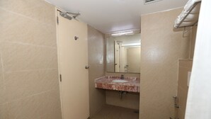 Un baño pequeño con inodoro, lavamanos y ducha.