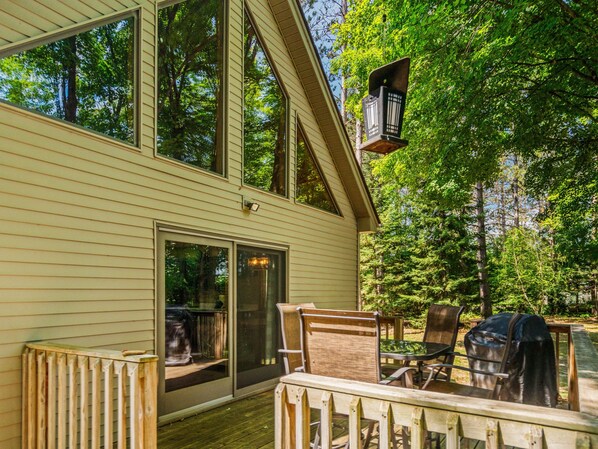 A deck with outdoor furniture, a sliding glass door, and a lantern.