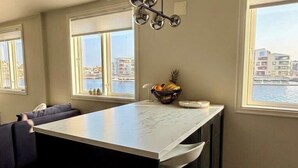 Una cucina con un piano di lavoro in marmo, forno integrato e vista sull'acqua.