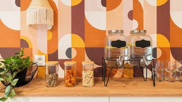 A kitchen counter with jars of snacks, a hanging lamp, and a potted plant.