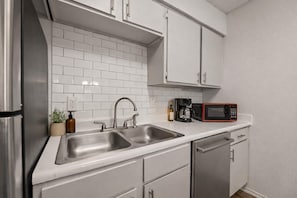 A modern kitchen with stainless steel appliances, white cabinetry, and a double sink. - Arlington Adventure • 2 Bedrooms • Sleeps 4 (Arlington)