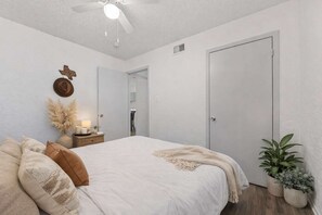 A bedroom with a bed, bedside table, lamp, and a ceiling fan. - Arlington Adventure • 2 Bedrooms • Sleeps 4 (Arlington)
