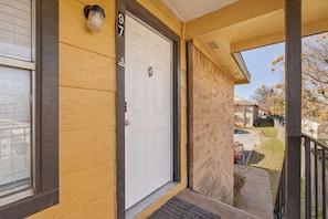 A residential building with a white front door, a number '97' sign, and a covered porch area. - Arlington Adventure • 2 Bedrooms • Sleeps 4 (Arlington)