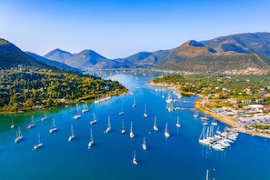 Ein Yachthafen mit zahlreichen Segelbooten, umgeben von üppigen grünen Hügeln und Bergen.