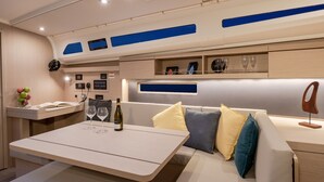Ein modernes Interieur mit einer Sitzecke, einem Tisch mit Flasche und Gläsern sowie einer Bedienkonsole.