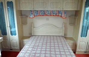 Ein Schlafzimmer mit einem Bett, einem Kleiderschrank und einem Nachttisch.
