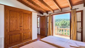A room with wooden doors, a balcony with curtains, and two beds with towels. - Finca with private pool in a quiet location near Felanitx (Felanitx)