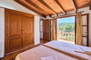 A room with wooden doors, a balcony with curtains, and two beds with towels. - Finca with private pool in a quiet location near Felanitx (Felanitx)