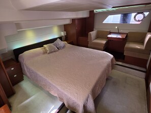 A bedroom with a large bed, a bedside table, a chair, and a window. - Sun-Kissed Sailing Adventure in Sibenik, Croatia (Primošten)