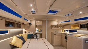 A compact interior with a dining area, kitchenette, and seating. - Caribbean Dream: Sun-soaked Sailing Adventure from Tortola, Islas Vírgenes Británicas (Road Town)