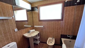 A bathroom with a toilet, sink, bidet, and bathtub. - Spacious 3-bedroom apartment on the front line by the sea. Rodes Lux-71 (Calafell)