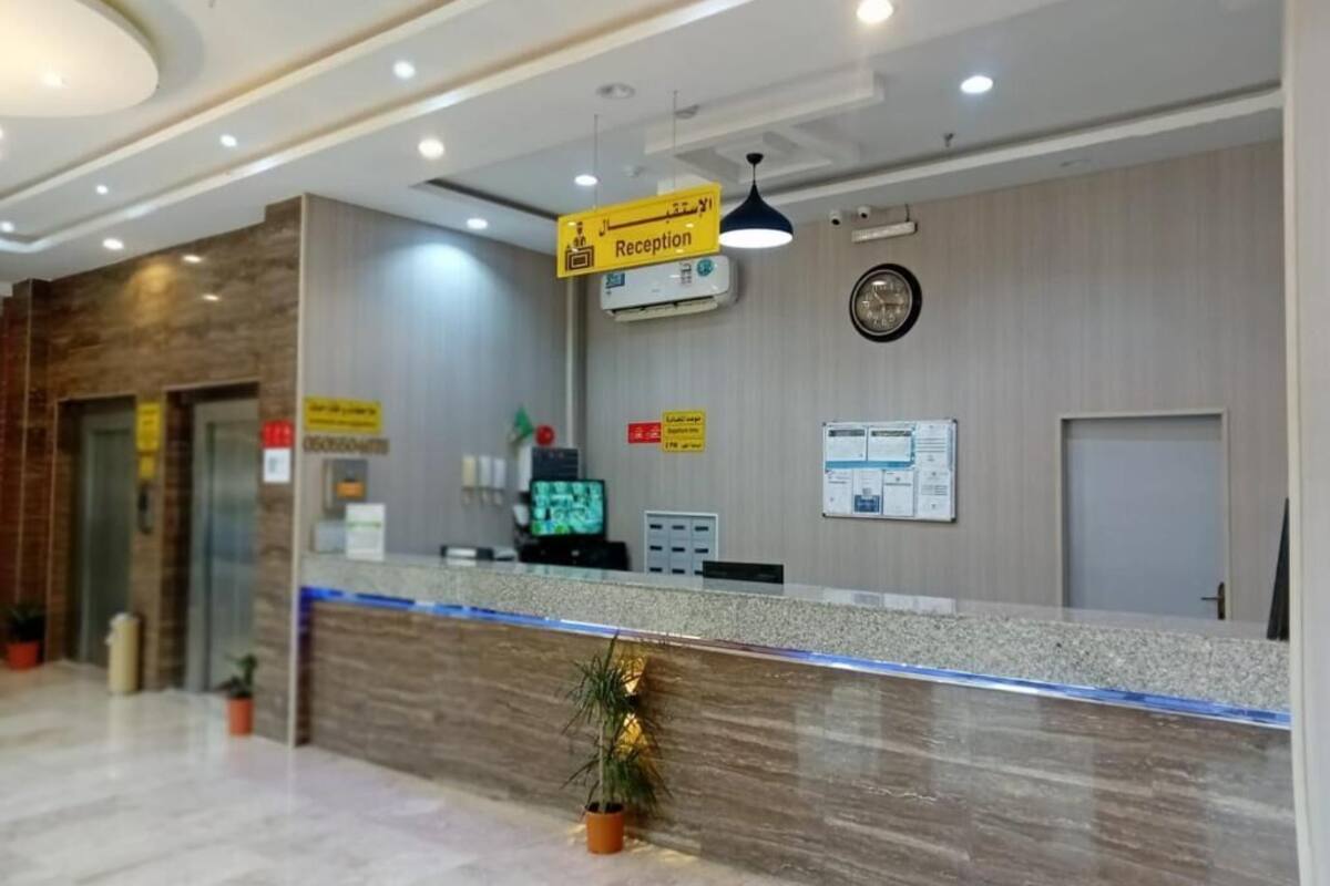 A reception area with a reception desk, a clock, and a sign indicating the reception.