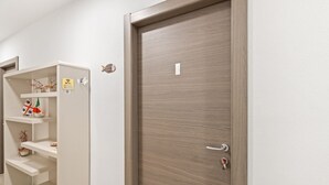Una habitación con puerta de madera, estantería blanca decorada y señal de WiFi.