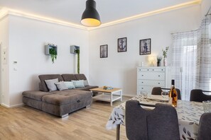 Una sala de estar moderna con un sofá, una mesa de centro, una mesa de comedor y sillas.