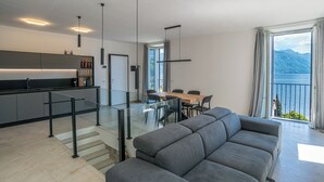 En moderne opholdsstue med sofa, spisebord og køkken.